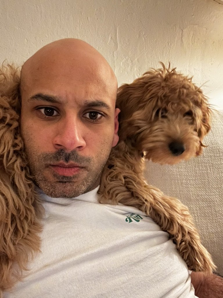 Ben the goldendoodle resting on Malek Damiri's shoulder
